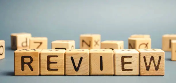 Photo of Wooden blocks with the word Review. Customer review concept. Reviewing, auditing, reviewer. Service rating. Feedback.