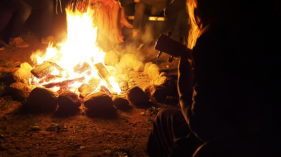 Friends celebrating and having fun around a bonfire.