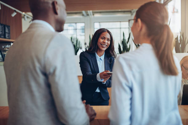 istock Smiling African American hotel concierge helping guests during check in 1182669256