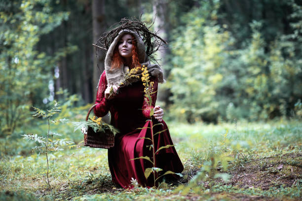 istock The red-haired witch holds a ritual with a crystal ball 1182669380