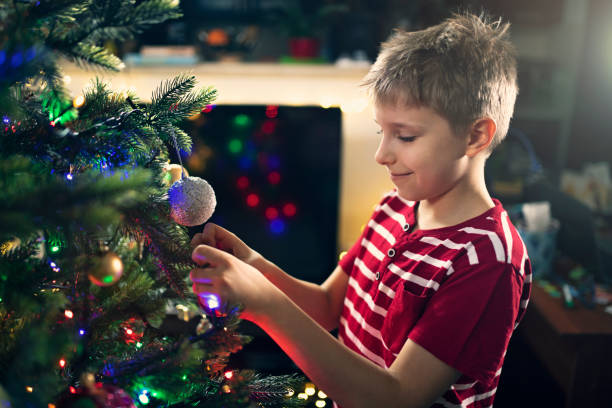 istock Cute little boy decorating Christmas tree 1182669751