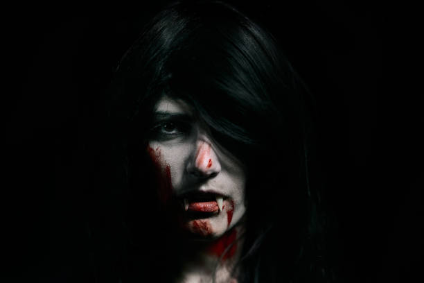 istock Halloween Vampire Beautiful Woman over black 1182672219