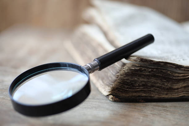 istock Old books on a wooden table and magnifier 1182672468