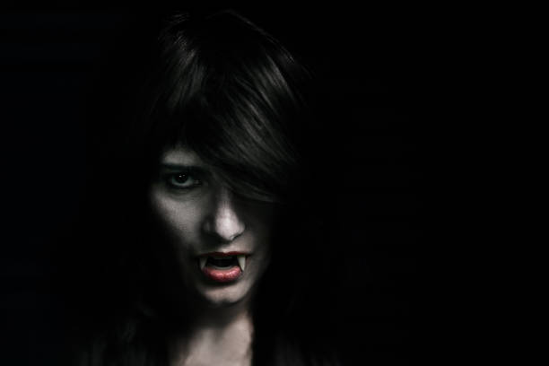 istock Halloween Vampire Beautiful Woman over black 1182672487