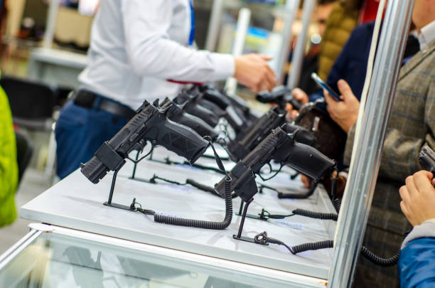 gun display stands. pistols for sale in the store. - armamento imagens e fotografias de stock