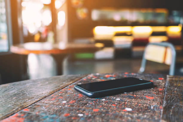 a single mobile phone on the table - copy space left imagens e fotografias de stock