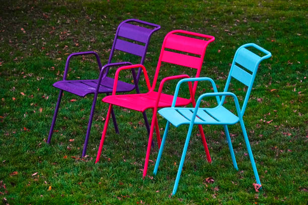 istock Three colorful chairs on the meadow 1182679098