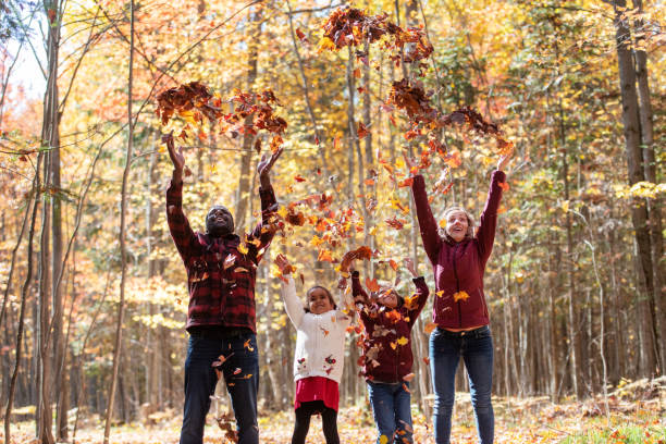 istock Mixed raced family throwing maple leaves 1182680477