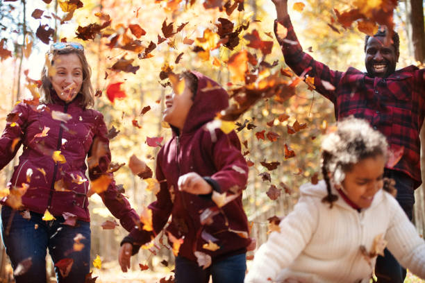 istock Mixed raced family throwing maple leaves 1182680608