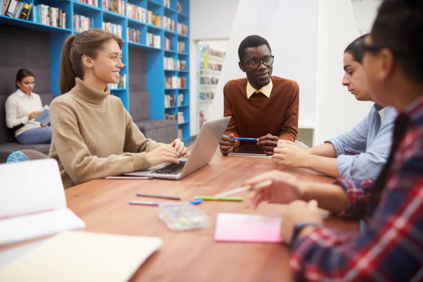 istock Team of Students Discussing Project in Library 1182682484