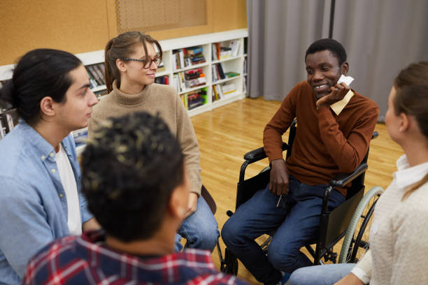 istock Smiling Man in Wheelchair Sharing with Support Group 1182682793