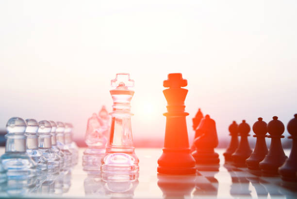 istock Transparent and black chess pieces on the board 1182683339