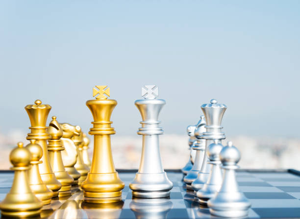 istock Golden and silver chess pieces on the board 1182684303