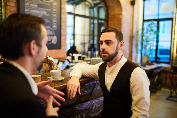 istock Business People Sitting at Bar Counter 1182684425