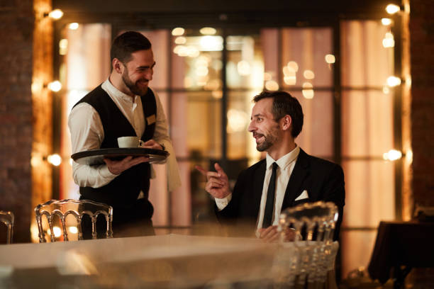 istock Smiling Businessman ordering Coffee in Restaurant 1182684610