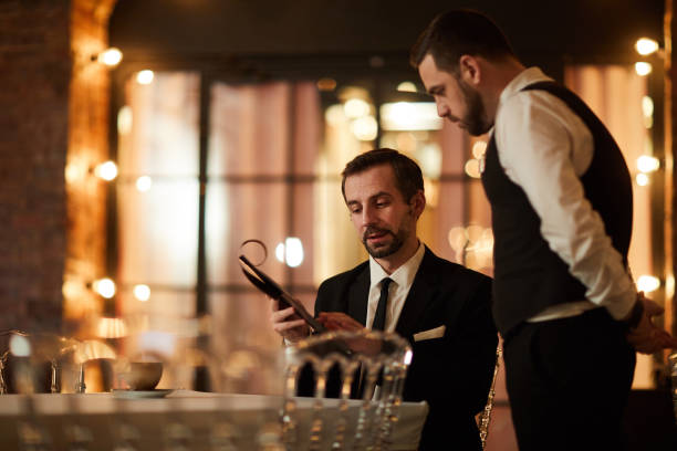 istock Mature Businessman Reading Menu in Restaurant 1182684613