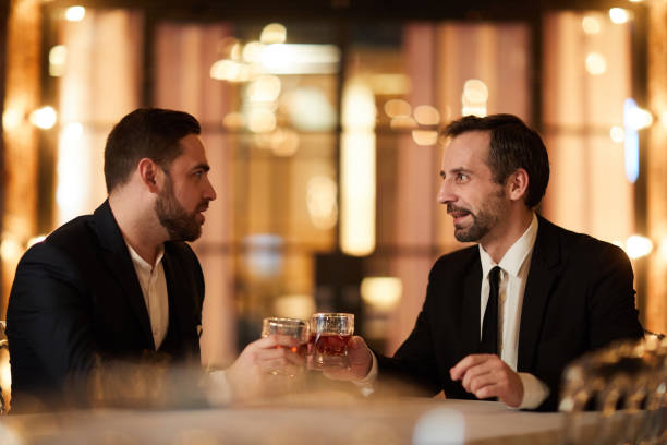 istock Two Business People Celebrating in Restaurant 1182684667