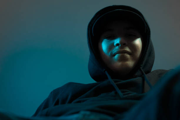 istock young cool smiling rapper with black hoodie and cap looking down 1182685542