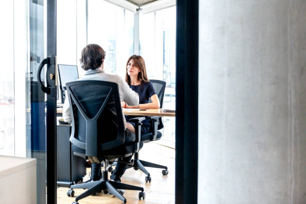 Woman Interviewing a man for a job stock photo