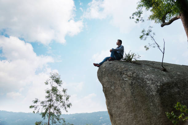 istock A man sitting on cliff enjoy the view 1182687767