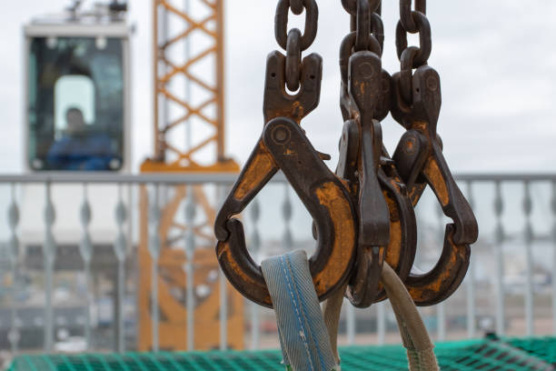 Closeup of four crane hooks with straps attached