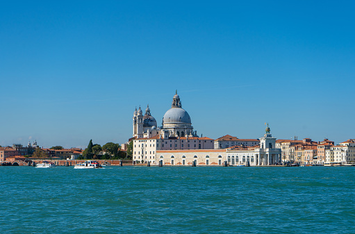 View of Ponta della Dogana and Santa Maria della Salute church dome from the Giudecca Canal at Venice, Italy. The building Dogana da Mar in Dorsoduro was built in the 15th century for customs and docking porposes and is now an art museum. It is right in the point where Grand Canal and Giudecca Canal meet and in front of the main island of Venice and it can be seen from the main island through the Grand Canal.