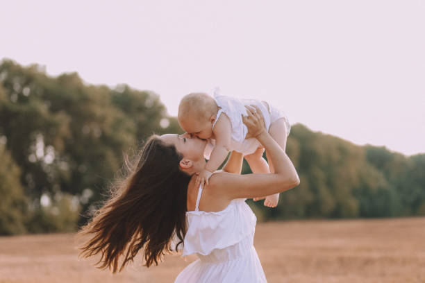 istock mother small daughter white dresses field straw 1182693574
