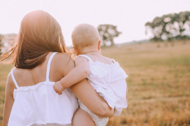 istock mother small daughter white dresses field straw 1182693577