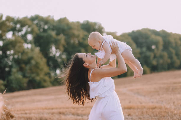 istock mother small daughter white dresses field straw 1182693583