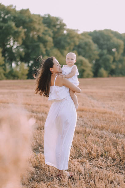 istock mother small daughter white dresses field straw 1182693592