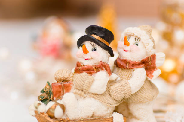 Snowman couple on a sleigh with present