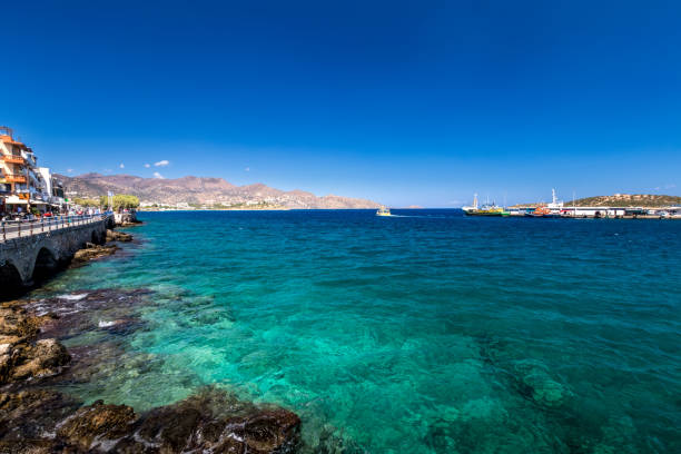 istock Agios Nikolaos coastline on a sunny day with clear sea and cliffs. 1182695312