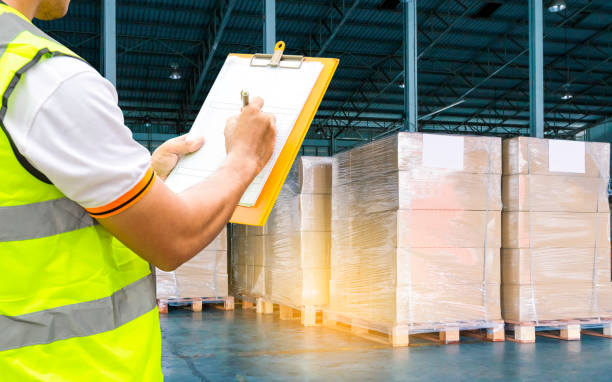 istock Worker hand holding clipboard inspecting checklist orders shipment goods pallets. 1182696780