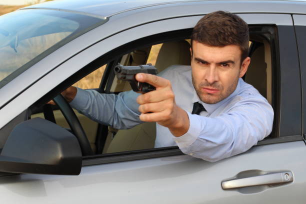istock Secret agent holding gun while driving 1182697037