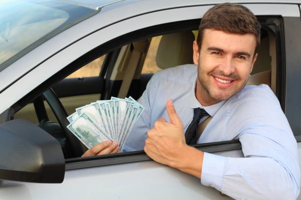 American driver holding 100 dollar bills American driver holding 100 dollar bills. cash for cars stock pictures, royalty-free photos & images