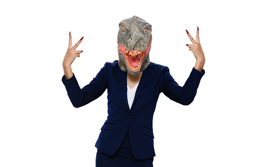 One person / front view / looking at camera of 20-29 years old adult beautiful black hair / long hair latin american and hispanic ethnicity female / young women businesswoman / business person standing wearing skirt / businesswear / blazer - jacket / jacket / mask - disguise / costume / a suit who is humor / wearing dinosaur mask