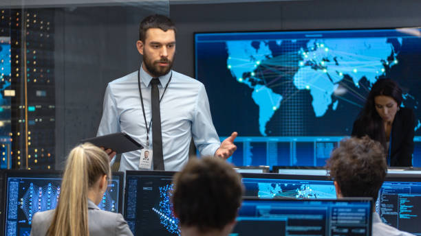 istock Chief Project Engineer Holds Briefing for a Team of Scientists that are Building Machine Learning System. Displays Show Working Model of Neural Network. 1182697720