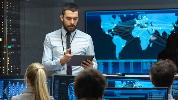 istock Chief Project Engineer Holds Briefing for a Team of Scientists that are Building Machine Learning System. Displays Show Working Model of Neural Network. 1182697734
