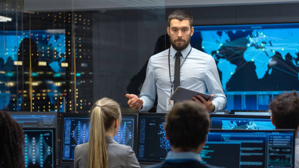 istock Chief Project Engineer Holds Briefing for a Team of Scientists that are Building Machine Learning System. Displays Show Working Model of Neural Network. 1182697750