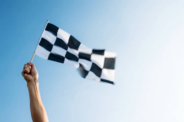 istock Man hand holding checkered flag in the wind 1182700921