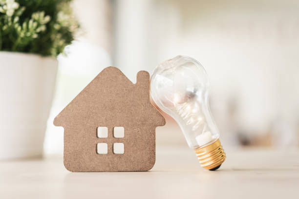 istock Light bulb with wood house on the table, a symbol for construction, Creative light bulb idea, power energy or business idea concept ecology, loan, mortgage, property or home. 1182701883