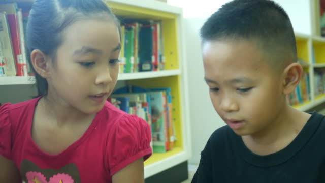 Asian children learning together in library