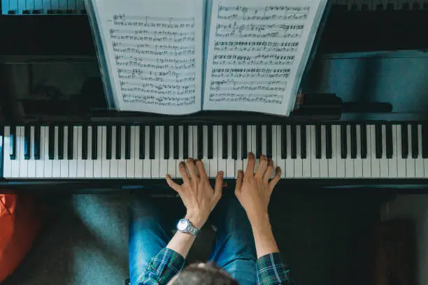 Photo of High angle view of a pianist playing piano