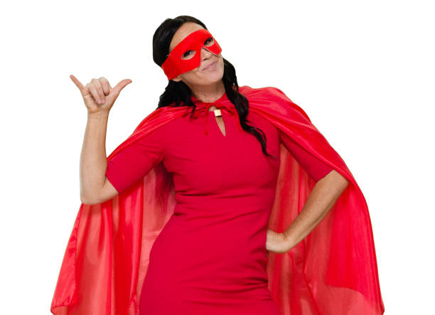 front view / one person / waist up / portrait of adult beautiful black hair caucasian female / young women superhero / heroines / hero standing wearing dress / eye mask / mask - disguise / costume / cape - garment / cool attitude and celebration - thank you excitement waist up horizontal imagens e fotografias de stock