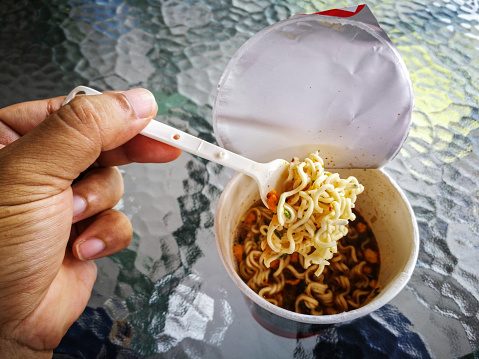 Hot and Spicy Instant cup noodles with shrimp  on \nglass table