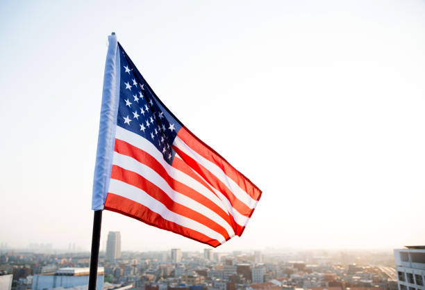 istock American flag waving in sunset 1182705318