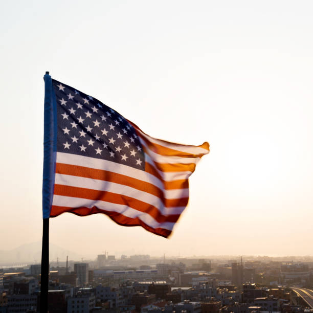 istock American flag waving in sunset 1182705486