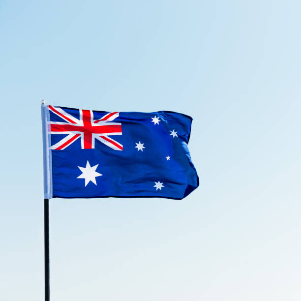 istock Waving Australia flag against blue sky 1182705545