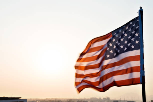 istock American flag waving in sunset 1182705636