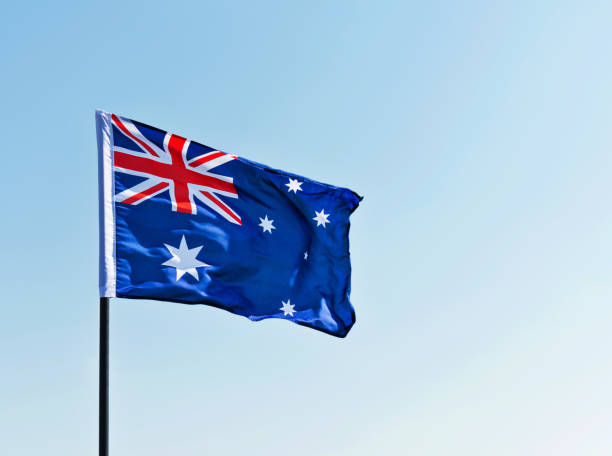 istock Waving Australia flag against blue sky 1182706307